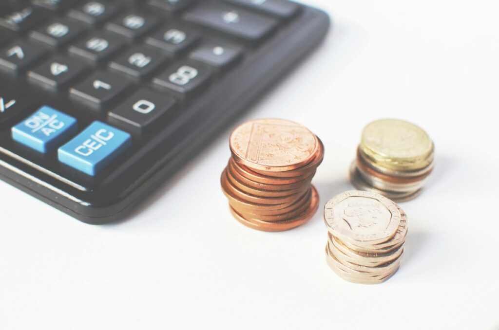 Close-up of stacked coins and a calculator symbolizing financial strategy and budgeting.